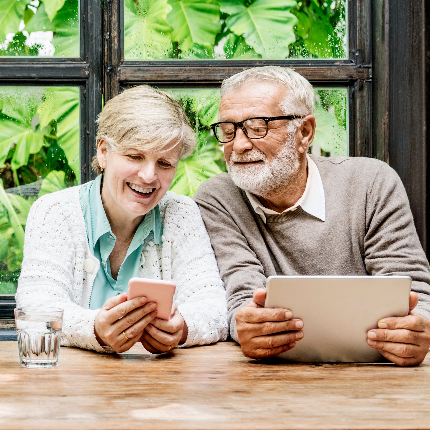 An older couple using their devices